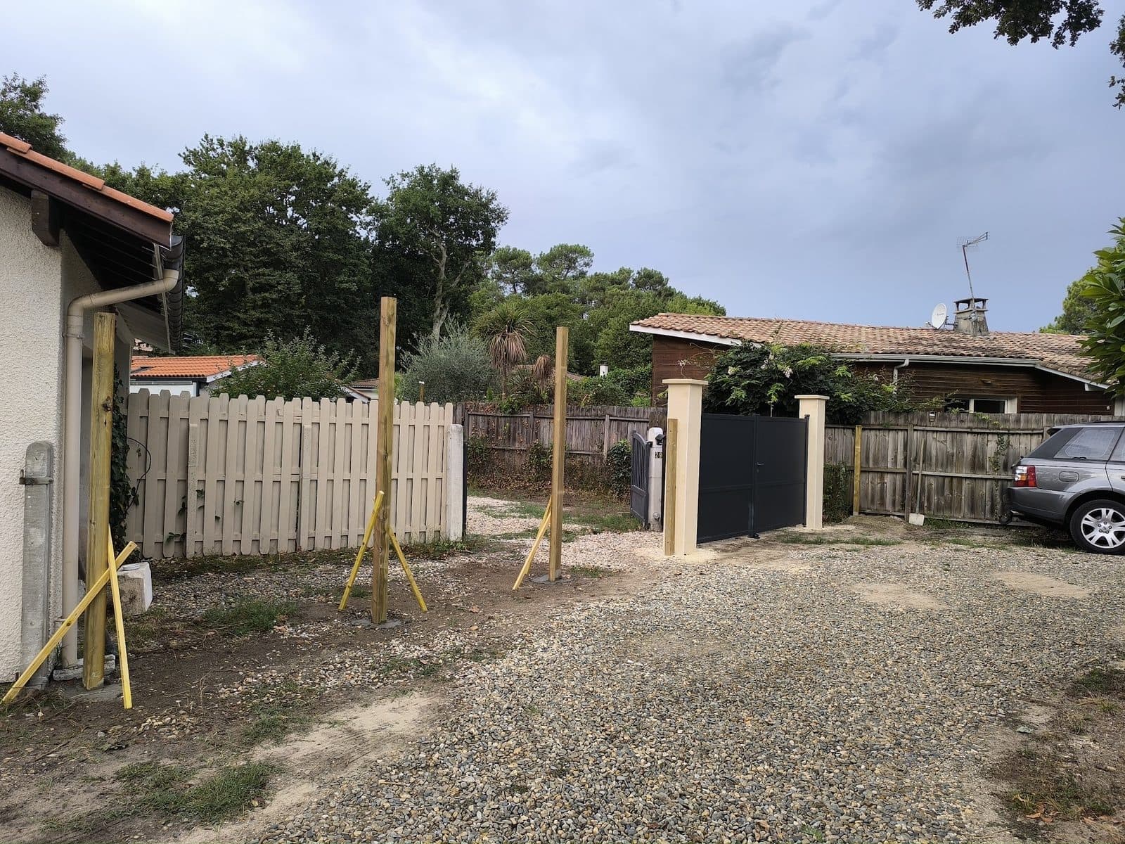 Poteaux de clôture maintenus par des liteaux près du portail, avant la pose des lambourdes
