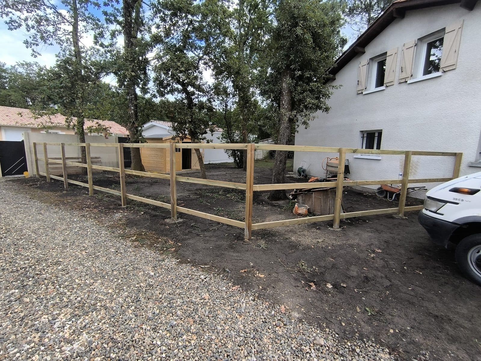 Ossature de clôture bois terminée : poteaux et trois rangs de lambourdes autour du jardin
