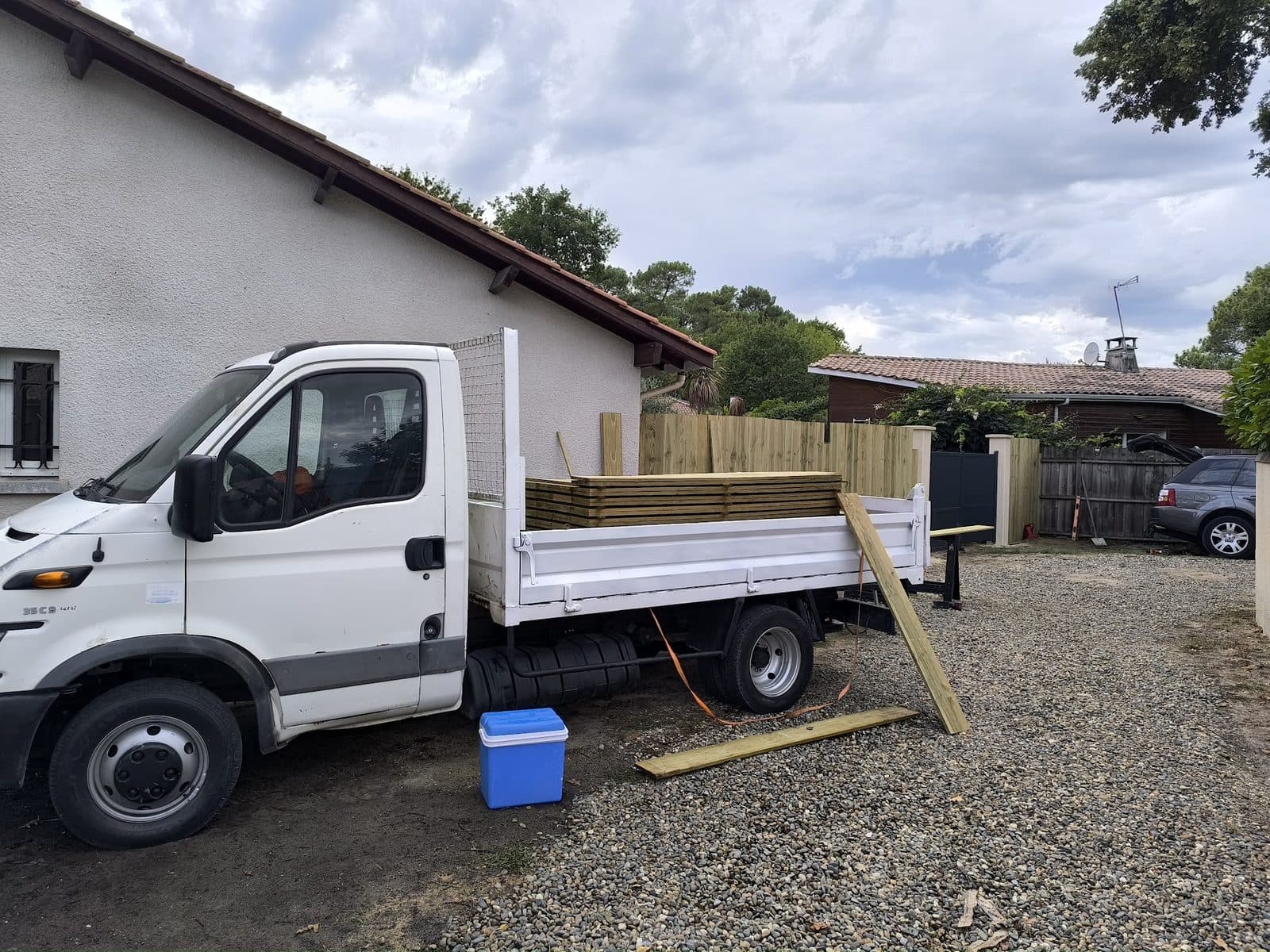 Livraison des lames bois sur le chantier de clôture, premières lames posées au fond