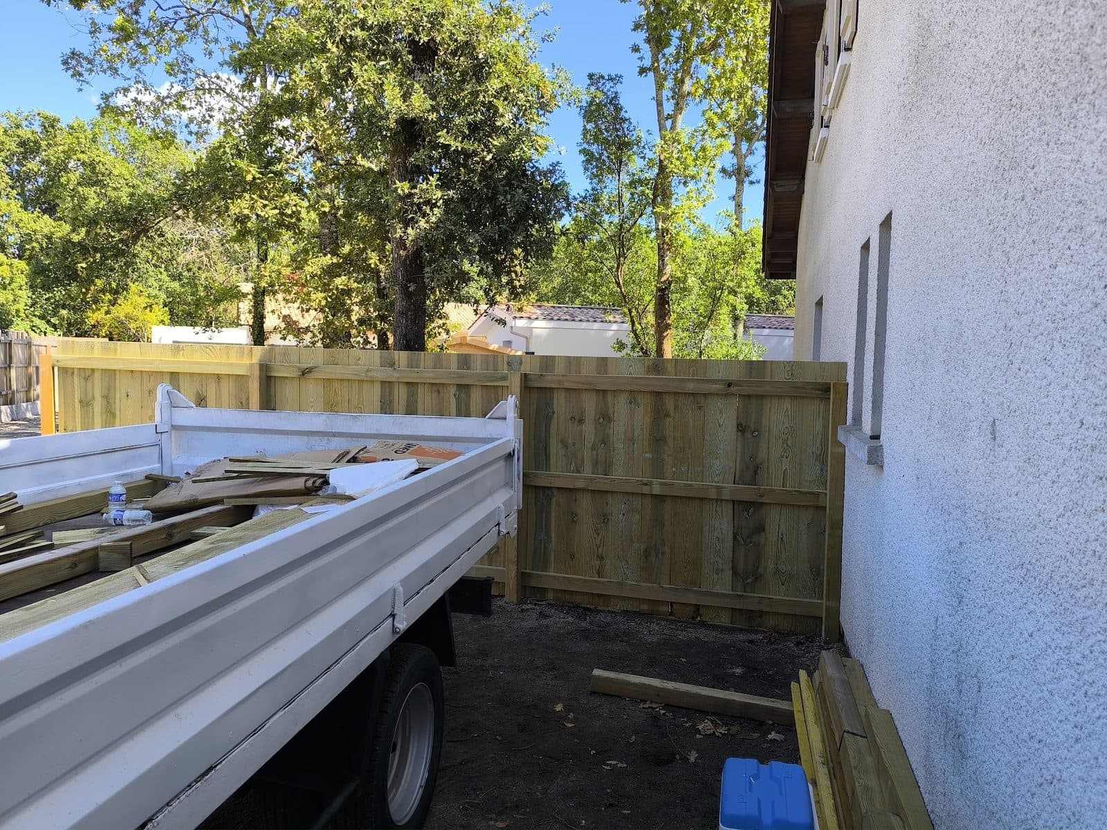 Angle de la clôture bois terminé contre le mur de la maison